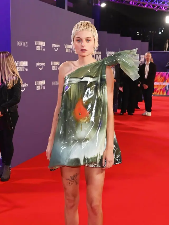 Gaya Nyeleneh Emma Corrin Pakai Gaun Kantong Plastik Berisi Ikan Mas Koki di London Film Festival