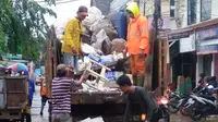 Petugas mengangkut sampah akibat banjir di Tangerang. (Liputan6.com/Pramita Tristiawati)