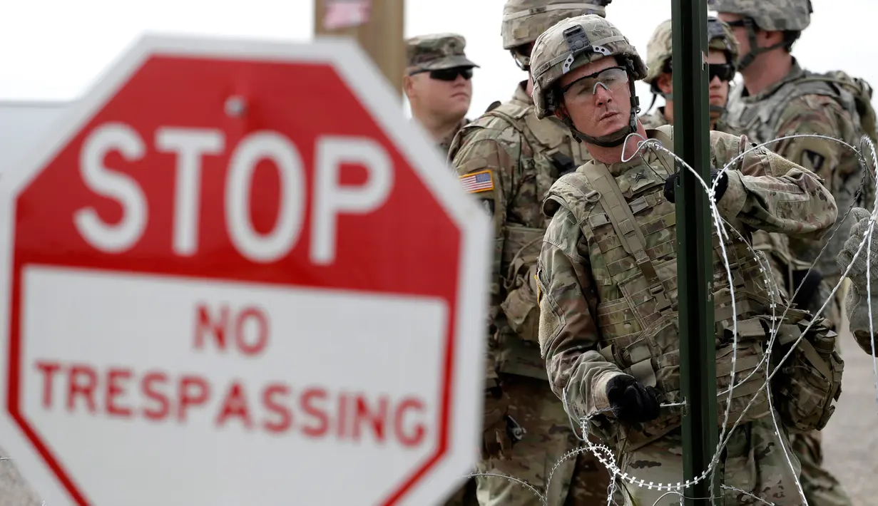 Tentara AS memasang kawat duri dekat jembatan perbatasan antara AS dengan Meksiko di Donna, Texas, Minggu (4/11). AS mengerahkan lebih dari 5.200 serdadu ke perbatasan Meksiko untuk menghalau imigran. (AP Photo/Eric Gay)