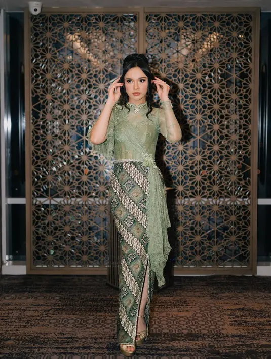 Lyodra memukau perhatian publik saat tampil anggun mengenakan kebaya hijau muda yang dimodifikasi dengan siluet kebaya brokat yang elegan. Desainnya yang memiliki kerah tinggi memberikan sentuhan klasik yang sangat menawan, sementara aksen selendang menambah kesan dramatis. [@lyodraofficial]