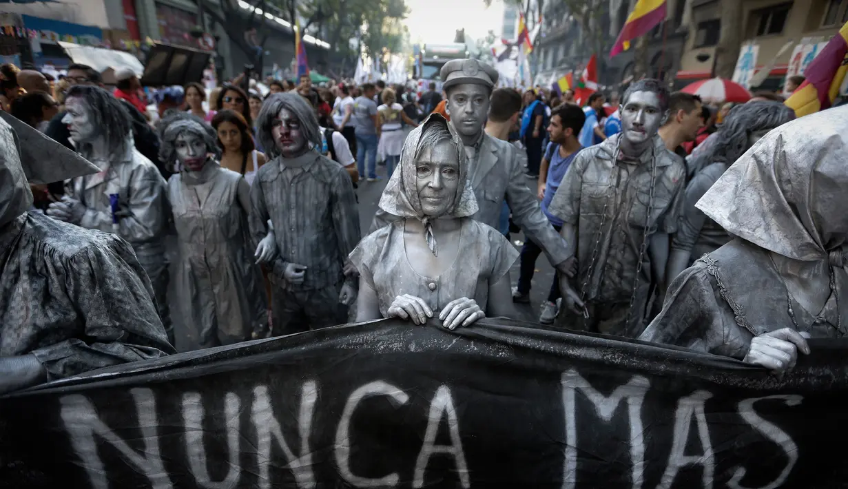 Sejumlah peserta membawa spanduk yang bertuliskan dalam bahasa Spanyol "tidak pernah lagi" saat mengikuti peringatan 41 tahun kudeta militer di Buenos Aires, Argentina (24/3). (AP Photo/Victor R. Caivano)