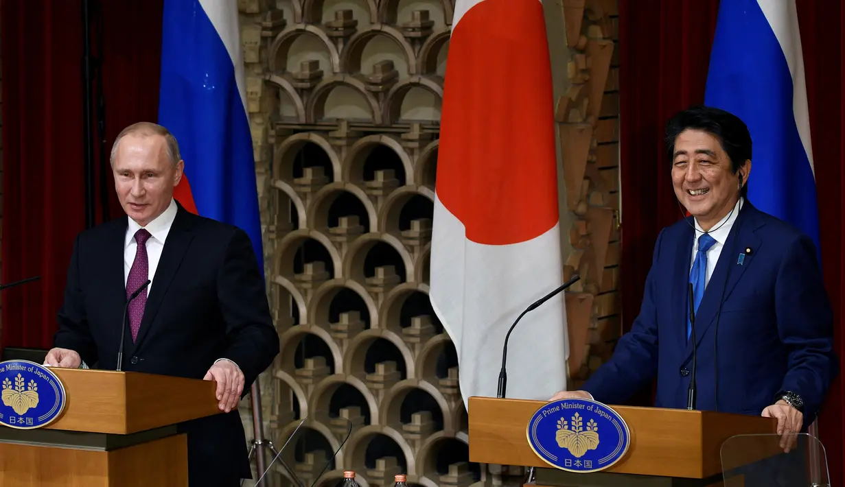 Presiden Rusia Vladimir Putin (Kiri) dan PM Jepang Shinzo Abe menggelar konferensi pers di Tokyo, Jepang, Jumat (16/12). Selain membahas soal wilayah sengketa, kedua belah pihak juga membahas situasi di semenanjung Korea. (REUTERS / Franck Robichon)