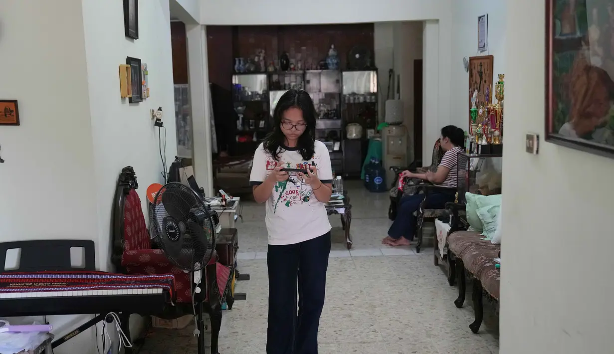 Menteri Komunikasi dan Digital (Menkomdigi), Meutya Hafid, menegaskan pemerintah Indonesia tidak akan berkompromi dengan platform digital yang tidak mematuhi amanat PP nomor 17 tahun 2025 tentang Pelindungan Tata Kelola Penyelenggaraan Sistem Elektronik dalam Pelindungan Anak. Tampak dalam foto, Maura Munthe memainkan permainan daring (online game platform), Roblox, melalui smartphone di rumahnya, Jakarta, 14 Maret 2026. (AP Photo/Dita Alangkara)