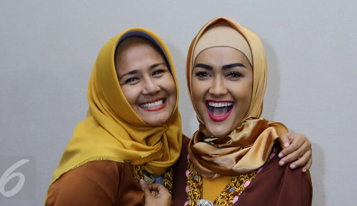Julia Perez (Jupe) bersama Ria Irawan berpose jelang keberangkatan menuju Mekkah di Bandara Seokarno Hatta, Tangerang, Senin (2/1). Meskipun belum genap seminggu menjalani operasi, Jupe tetap memutuskan berangkat umrah. (Liputan6.com/Herman Zakharia)