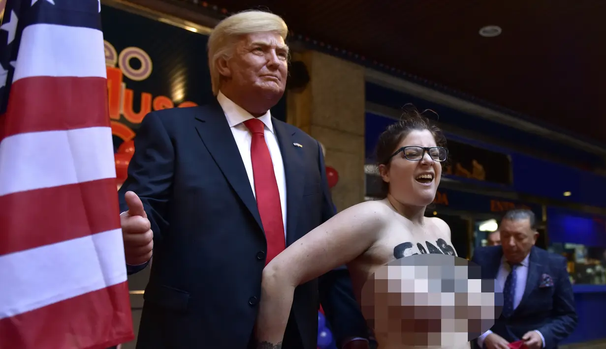 Aksi nekat aktivis Femen ini sebagai bentuk penolakan patung lilin Trump yang baru saja dihadirkan Museum Wax, Madrid, Spanyol, Selasa (17/1). (AFP PHOTO/GERARD JULIEN)