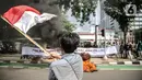 Pengunjuk rasa yang tergabung dalam gerakan nasional tolak reklamasi (Gentar) mengibarkan bendera merah putih didepan Gedung Balaikota, Jakarta, Rabu (8/7/2020). Dalam aksinya mereka meminta Gubernur DKI Jakarta Anies Baswedan untuk menghentikan Reklamasi Pantai Ancol. (Liputan6.com/Faizal Fanani)