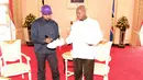 Rapper AS, Kanye West menandatangi sepatu kets yang diberikan sebagai hadiah untuk Presiden Uganda, Yoweri Museveni di Entebbe, Senin (15/10). Ini menjadi pertemuan kedua Kanye dengan pemimpin negara dalam sepekan. (AFP/UGANDAS PRESIDENTIAL PRESS OFFICE)