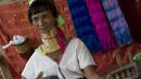 Seorang wanita etnis Kayan memainkan musik tradisional di desa PanPat, Kayan, Myanmar, Rabu (9/9/2015). Kaum perempuan Suku Kayan ini mengenakan banyak kalung berbentuk cincin di lehernya hingga membuat leher mereka panjang. (AFP PHOTO/Ye Aung THU)