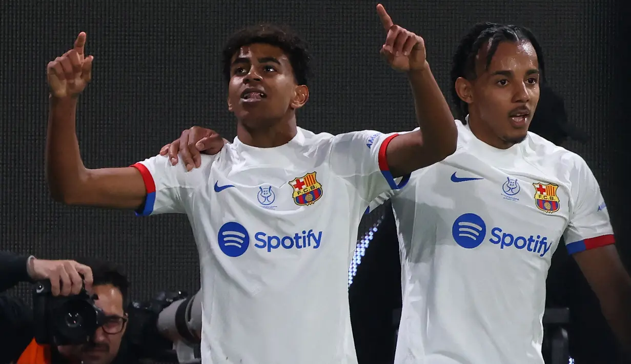 Lamine Yamal (kiri) yang baru bergabung bersama Barcelona pada awal musim 2023/2024 menjadi pemain termuda sepanjang sejarah yang mampu mencetak gol di ajang Piala Super Spanyol. Saat mencetak satu gol dan membawa Barcelona menang 2-0 atas Osasuna pada laga semifinal Piala Super Spanyol 2023/2024 (11/1/2024) usianya baru menginjak 16 tahun, 5 bulan dan 29 hari. (AFP/Fayez Nureldine)