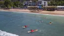 Para peserta berenang menuju area perlombaan dalam Kontes Selancar Phuket 2020 di Pantai Kalim di Phuket, Thailand (14/9/2020). Acara yang berlangsung selama tiga hari itu merupakan bagian dari kampanye pemerintah Thailand untuk mempromosikan pariwisata dan merangsang perekonomian. (Xinhua/Zhang Ker