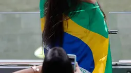 Fans wanita berpose dengan bendera Brasil sebelum pertandingan antara Brasil melawan Argentina pada semifinal Copa America 2019 di Stadion Mineirao, Brasil (2/7/2019). Di pertandingan ini Brasil menang 2-0 atas Argentina berkat gol striker Gabriel Jesus dan Roberto Firmino. (AP Photo/Nelson Antoine)