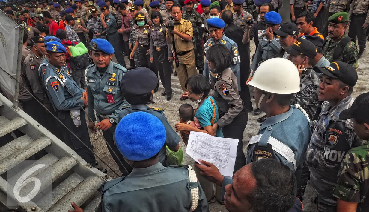 Petugas mendampingi mantan anggota Gafatar saat tiba di Pelabuhan Tanjung Emas, Semarang , Senin (25/1). Mantan anggota Gafatar terendah dari daerah Bandung, Jabar, 1 KK dengan jumlah 2 jiwa. (Liputan6.com/Gholib)