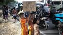 Anak-anak  saat meminta bunyi klakson telolet ke bus yang lewat di Jalan Raya Bogor, Jakarta, Sabtu (24/12). Fenomena ini mendunia setelah beberapa artis dan tokoh terkenal dunia berkomentar di media sosial. (Liputan6.com/ Faizal Fanani)