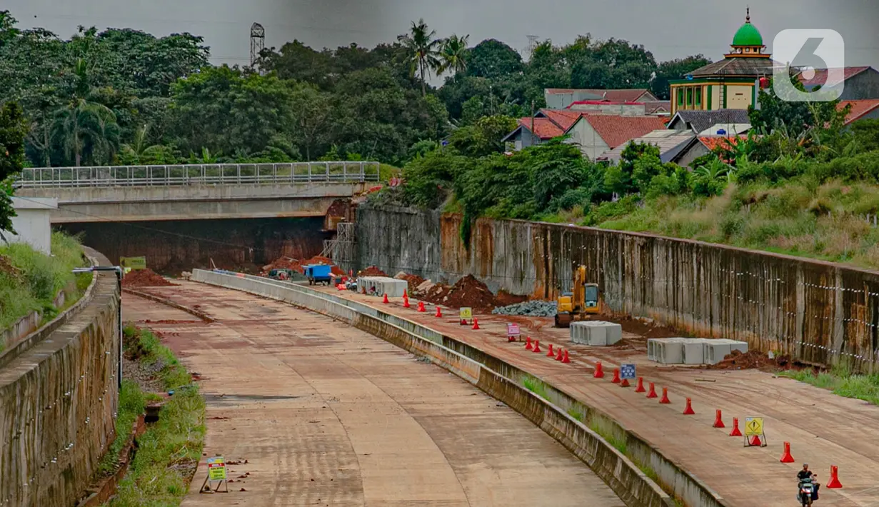 Pengendara motor terlihat melintas di proyek pembangunan jalan tol ruas Serpong - Cinere di Tangerang Selatan, Banten, Selasa (16/2/2021).  Konstruksi fisik jalan bebas hambatan berbayar sepanjang 14,19 kilometer tersebut akan tuntas pada April 2021 mendatang. (Liputan6.com/Faizal Fanani)