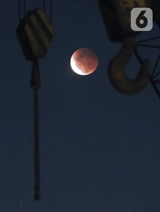 Gerhana bulan terlihat dari di Jalan Belah Kapal, Cilincing, Jakarta Utara pada Rabu (26/5/2021). Gerhana bulan yang disebut juga fenomena "Super Blood Moon" tersebut berlangsung sekitar lima jam lima menit dan dapat disaksikan dari seluruh Indonesia. (merdeka.com/Imam Buhori)