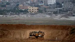 Tank tempur Israel, Merkava berpatroli di sepanjang perbatasan dengan Jalur Gaza, Palestina, Jumat (20/7). Selain menggunakan jet tempur, IDF juga mengerahkan tank untuk menyerang para milisi Hamas. (JACK GUEZ/AFP)