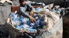 Seorang pekerja Afghanistan memasukkan botol plastik ke dalam karung di tempat daur ulang di Kabul pada 5 Agustus 2025. (Wakil KOHSAR/AFP)