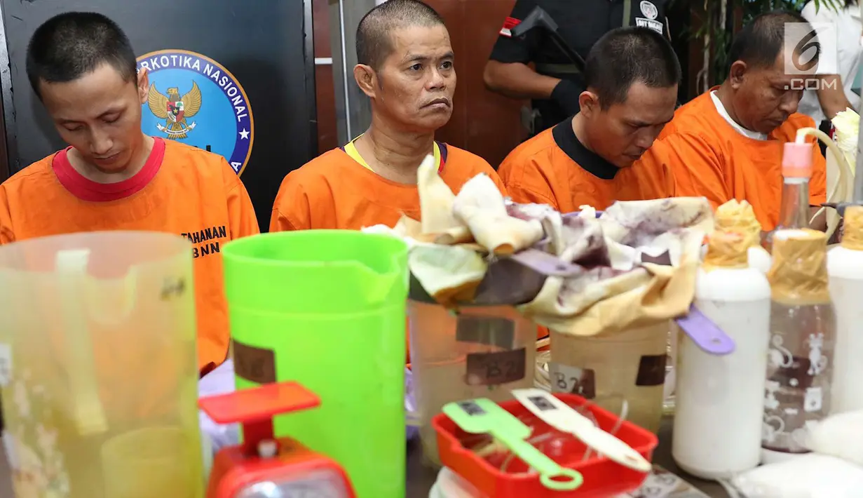 Tersangka kasus pabrik gelap narkoba di Majene saat rilis di Gedung BNN Jakarta, Kamis (9/8). Petugas mengamankan barang bukti berupa narkotika dan bahan pembuatnya. (Liputan6.com/Immanuel Antonius)