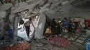 Perserikatan Bangsa Bangsa (PBB) pada Oktober 2025 memperkirakan 1,4 juta orang di Gaza sangat membutuhkan bantuan hunian darurat. Tampak dalam foto, Sahar Taroush berbicara dengan saudara laki-lakinya di rumahnya yang sebagian runtuh setelah kembali menyusul gencatan senjata terbaru, Jabaliya, Kota Gaza, Selasa, 11 November 2025. Terlihat juga anak-anaknya, Ammar paling kiri; Hassan dengan adik perempuannya yang berusia 2 tahun, Ahlam; dan Bisan, kanan. (AP Photo/Jehad Alshrafi)
