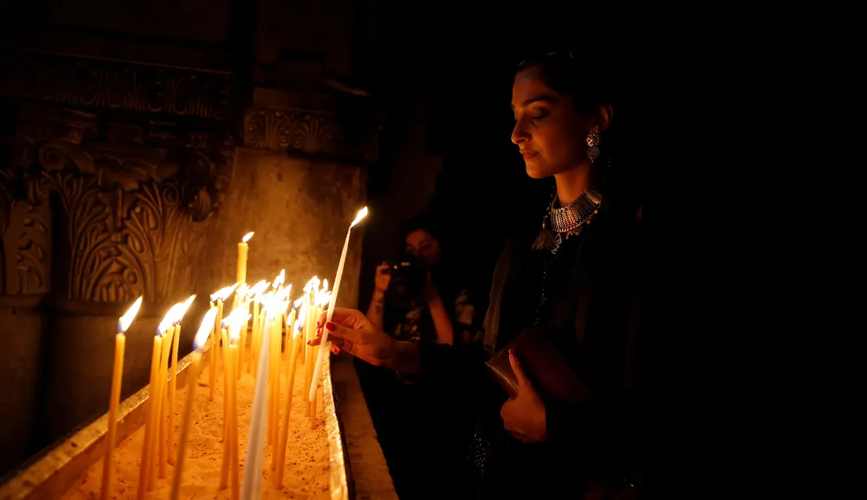 Sonam Kapoor membawa lilin saat mengunjungi Gereja Makam Suci di Kota Tua Yerusalem 30 Mei 2016. Dia adalah salah satu aktris dengan bayaran tertinggi dan selebriti paling modis di India. (REUTERS / Ammar Awad)