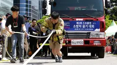 Petugas pemadam kebakaran Lim Sung-joo menarik sebuah truk pemadam kebakaran dengan seutas tali saat Safe Seoul Festival di Seoul, Korea Selatan, Kamis (9/5/2019). Safe Seoul Festival digelar untuk mengampanyekan kesadaran keselamatan. (AP Photo/Ahn Young-joon)