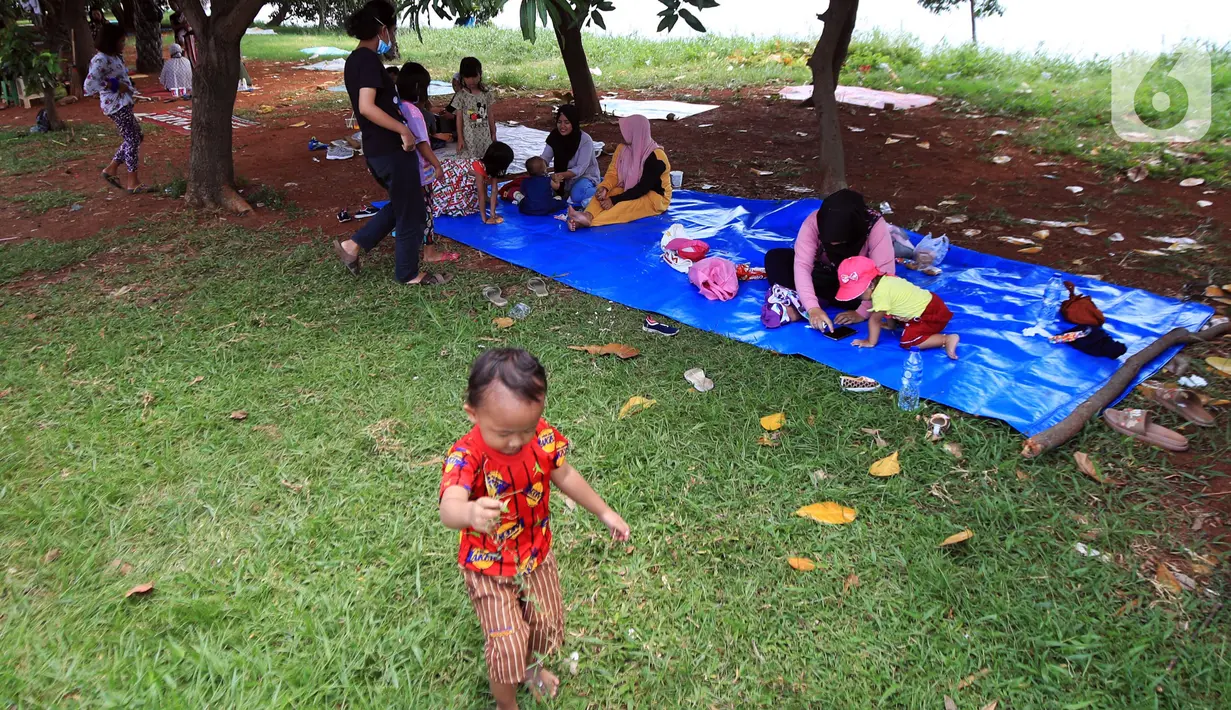 Orang-orang menikmati piknik di Taman Kota Waduk Pluit di Penjaringan, Jakarta Utara, Minggu (27/12/2020). Taman Kota Waduk Pluit dibuka kembali setelah ditutup pada libur Natal, namun banyak warga yang berwisata tidak menerapkan protokol kesehatan. (Liputan6.com/Johan Tallo)