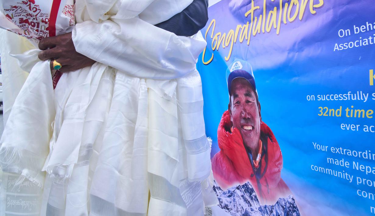 Pemandu gunung legendaris asal Nepal, Kami Rita Sherpa, yang kembali dari Gunung Everest setelah pendakiannya yang ke-32, menerima selendang dan bunga saat tiba di bandara, Kathmandu, Nepal, Jumat 22 Mei 2026. (AP Photo/Niranjan Shrestha)
