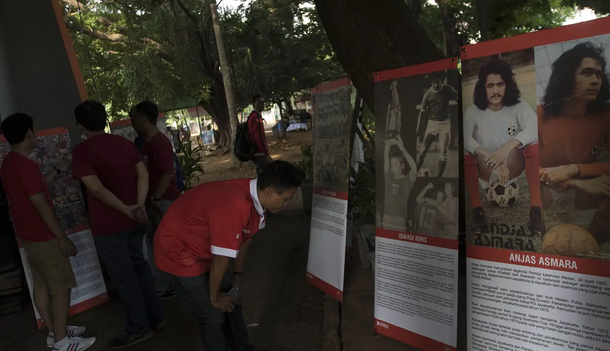 Pengunjung bernostalgia dengan sejarah sepak bola Jakarta melalui pameran foto memperingati hari jadi Persija Jakarta di Lapangan Banteng, Jakarta, Jumat (28/11/2015). (Bola.com/Vitalis Yogi Trisna)