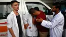 Sejumlah paramedis Palestina menangisi rekan mereka, Abdullah al-Qutati yang meninggal ditembak tentara Israel, Rafah, Jalur Gaza, Sabtu (11/8). (SAID KHATIB/AFP)