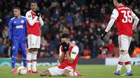 Penyerang Arsenal, Pierre-Emerick Aubameyang (tengah) menutup wajahnya usai pertandingan melawan Olympiakos pada leg kedua babak 32 besar Liga Europa di stadion Emirates, London, Kamis (27/2/2020).  Olympiakos menang 2-1 dan lolos dengan unggul agregat gol tandang 2-2. (AP Photo/Frank Augstein)