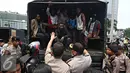 Mahasiswa Papua berada di dalam mobil petugas usai berunjuk rasa di kawasan Bunderan HI, Jakarta, Selasa (1/12). Massa menyerahkan diri sebagai bentuk solidaritas usai puluhan lainnya diamankan petugas pascabentrok. (Liputan6.com/Immanuel Antonius)