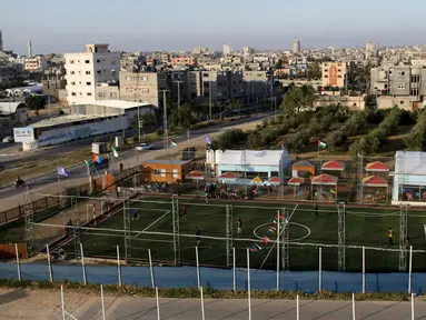 Warga Palestina bermain sepak bola di lapangan futsal, Khan Younis, Jalur Gaza, (4/6). Meski negara tersebut mengalami berbagai konflik tetapi mereka tetap menghibur diri dengan bermain bola bersama. (REUTERS / Ibraheem Abu Mustafa)