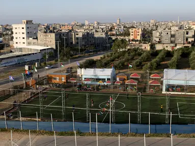 Warga Palestina bermain sepak bola di lapangan futsal, Khan Younis, Jalur Gaza, (4/6). Meski negara tersebut mengalami berbagai konflik tetapi mereka tetap menghibur diri dengan bermain bola bersama. (REUTERS / Ibraheem Abu Mustafa)