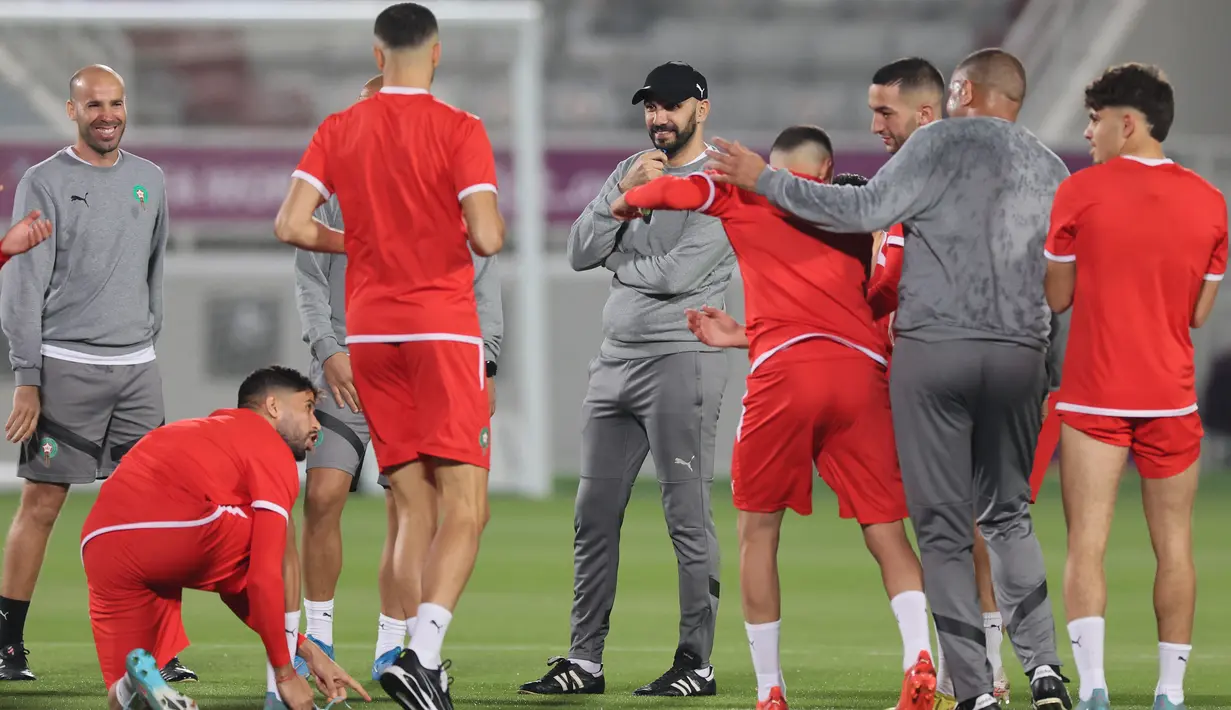 <p>Pelatih Maroko, Walid Reragui berbicara kepada para pemain selama sesi latihan latihan jelang menghadapi Prancsi di babak semifinal Piala Dunia 2022 di Stadion Al Duhail SC di Doha pada 13 Desember 2022. Maroko mengukir sejarah di Piala Dunia. Mereka jadi tim Afrika pertama yang tembus semifinal, usai mendepak tim kuat Portugal. (AFP/Karim Jaafar)</p>
