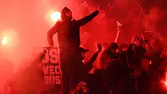 Pendukung Paris Saint-Germain menyalakan suar atau flare saat pertandingan melawan Real Madrid di stadion Parc des Princes di Paris (6/3). Dalam pertandingan ini PSG kalah 1-2 atas Real Madrid. (AFP Photo/Franck Fife)