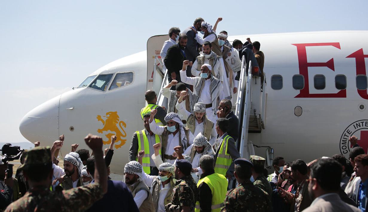 Tahanan Yaman meneriakkan slogan-slogan selama kedatangan mereka setelah dibebaskan oleh koalisi pimpinan Arab Saudi di Bandara Sanaa, Yaman, Kamis (15/10/2020). Pihak yang bertikai di Yaman menyelesaikan pertukaran tahanan besar yang ditengahi PBB pada hari Jumat. (AP Photo/Hani Mohammed)