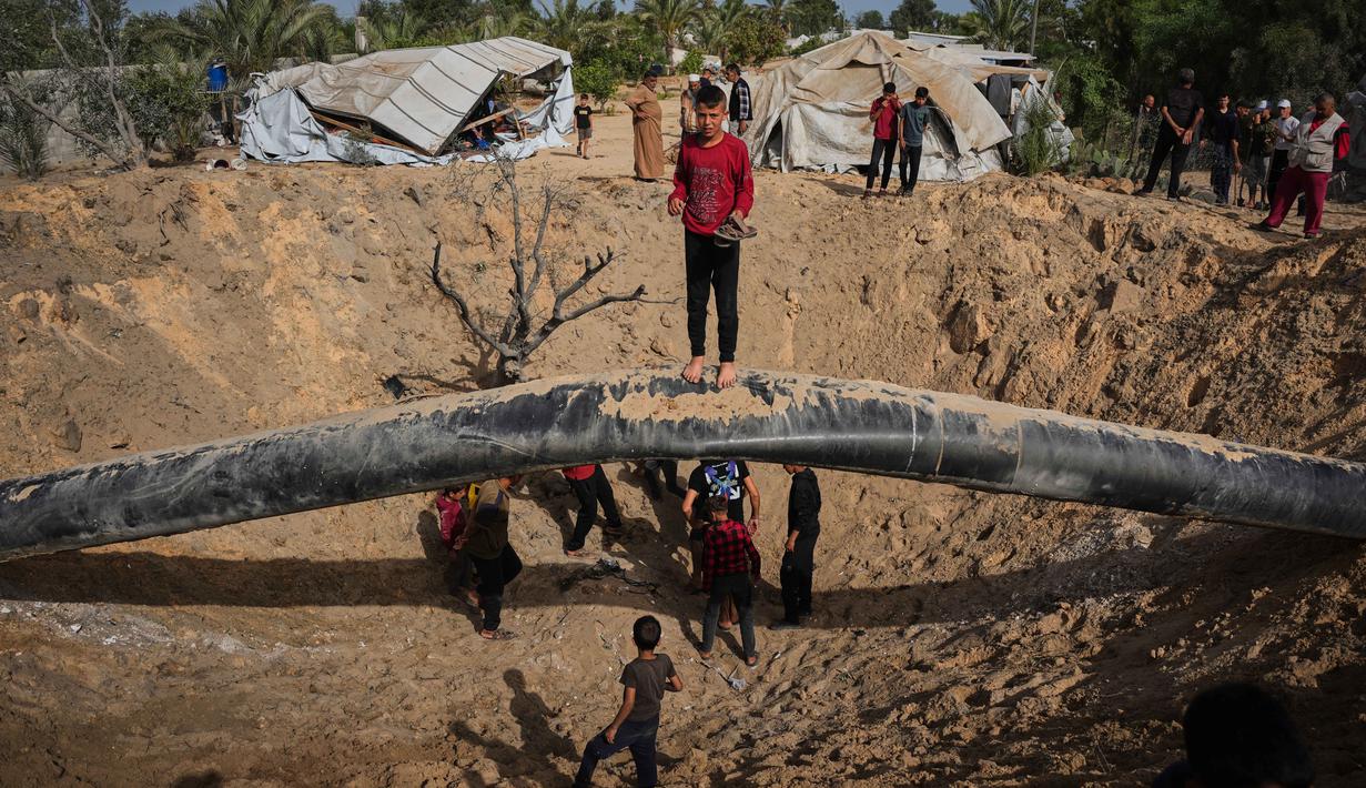 Warga Palestina memeriksa kerusakan akibat serangan Israel di Khan Younis, Jalur Gaza selatan, Selasa 19 Mei 2026. (AP Photo/Abdel Kareem Hana)