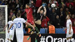 Kiper Islandia, Hannes Halldersson, menepis sundulan bintang Portugal, Cristiano Ronaldo, pada laga Grup F Piala Eropa di Stadion Geoffroy Guichard, St Etienne, Rabu (14/6/2016). Islandia bermain imbang 1-1 dengan Portugal. (AFP/Jeff Pachoud)