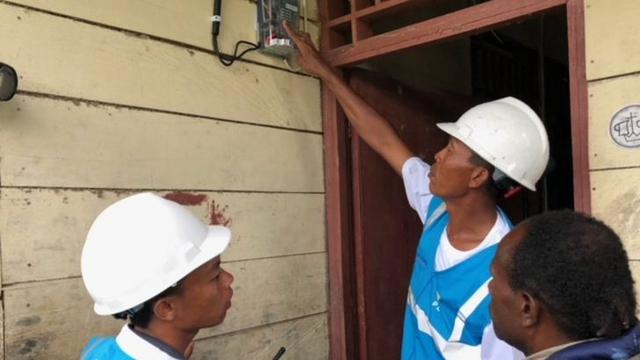 Petugas PLN memasang listrik di rumah warga di Desa Parauto, Nabire, Papua. (Vina A. Muliana/Liputan6.com)
