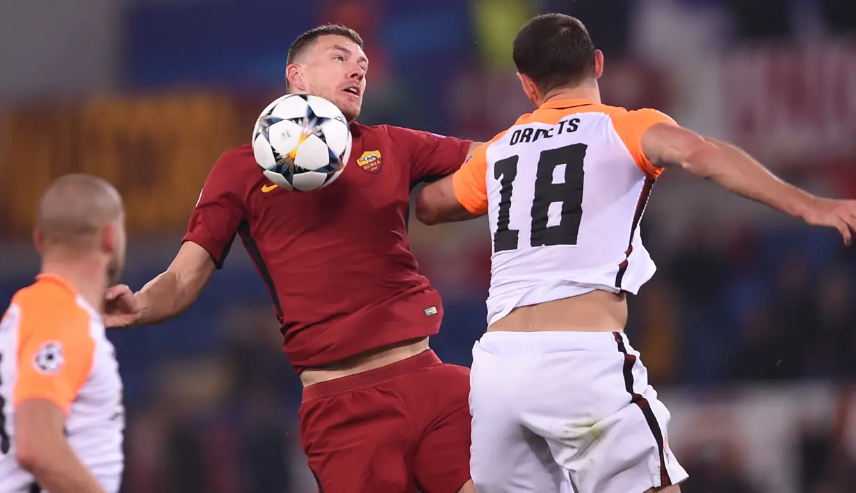 Pemain AS Roma, Edin Dzeko berebut bola dengan pemain Shakhtar Donetsk, Ivan Ordets pada leg kedua 16 besar Liga Champions 2017-2018  di Stadion Olimpico, Rabu (14/3). AS Roma melaju ke perempatfinal usai menang 1-0. (Filippo MONTEFORTE/AFP)