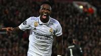 Pemain Real Madrid, Vinicius Jr melakukan selebrasi setelah mencetak gol penyeimbang 2-2 melalui blunder kiper Liverpool, Alisson Becker saat laga leg pertama Liga Champions 2022/2023 melawan Real Madrid yang berlangsung di Anfield, Rabu (22/02/2023) WIB. Liverpool kalah dengan skor 2-5 dari Real Madrid. (AFP/Paul Ellis)