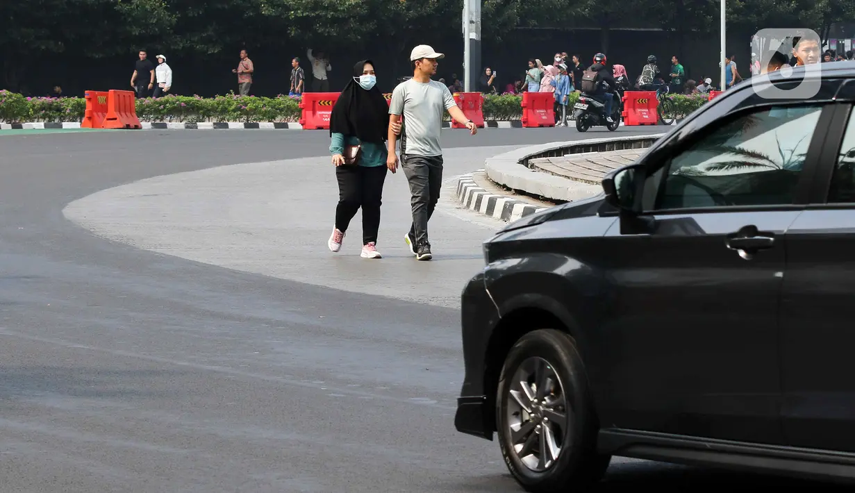 Terdengar imbauan dari pos polisi yang memperingatkan warga agar tidak turun ke badan jalan sebab lalu lintas di sekitar lokasi sedang ramai. Namun masih banyak warga tidak mengindahkan peringatan tersebut. (Liputan6.com/Herman Zakharia)