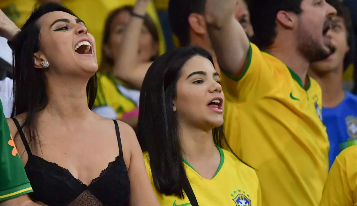 Dua fans wanita bersorak menunggu pertandingan antara Brasil melawan Argentina pada semifinal Copa America 2019 di Stadion Mineirao, Belo Horizonte, Brasil (2/7/2019). Di pertandingan ini Brasil menang 2-0 atas Argentina berkat gol striker Gabriel Jesus dan Roberto Firmino. (AFP Photo/Luis Acosta)