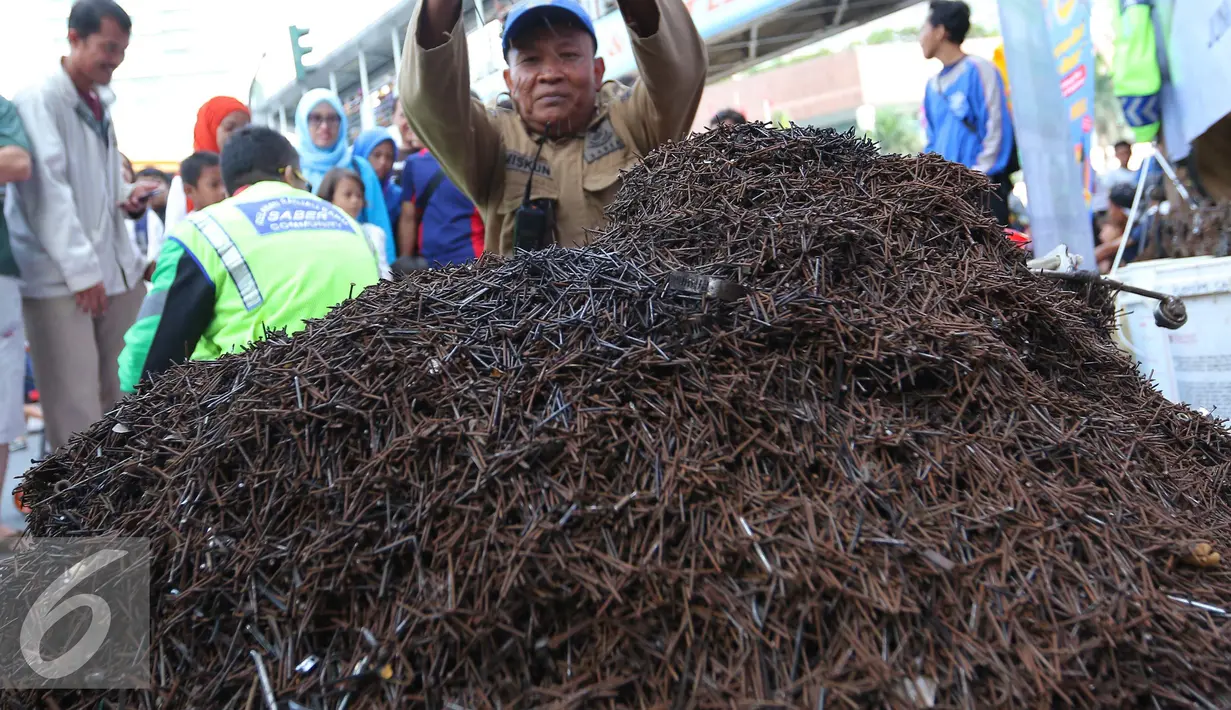Relawan dari Komunitas Sapu Bersih (Saber) berhasil menemukan 1,5 ton ranjau paku dari sejumlah ruas jalan Ibu Kota di Bundaran HI, Jakarta, Minggu (7/8). (Liputan6.com/Angga Yuniar)