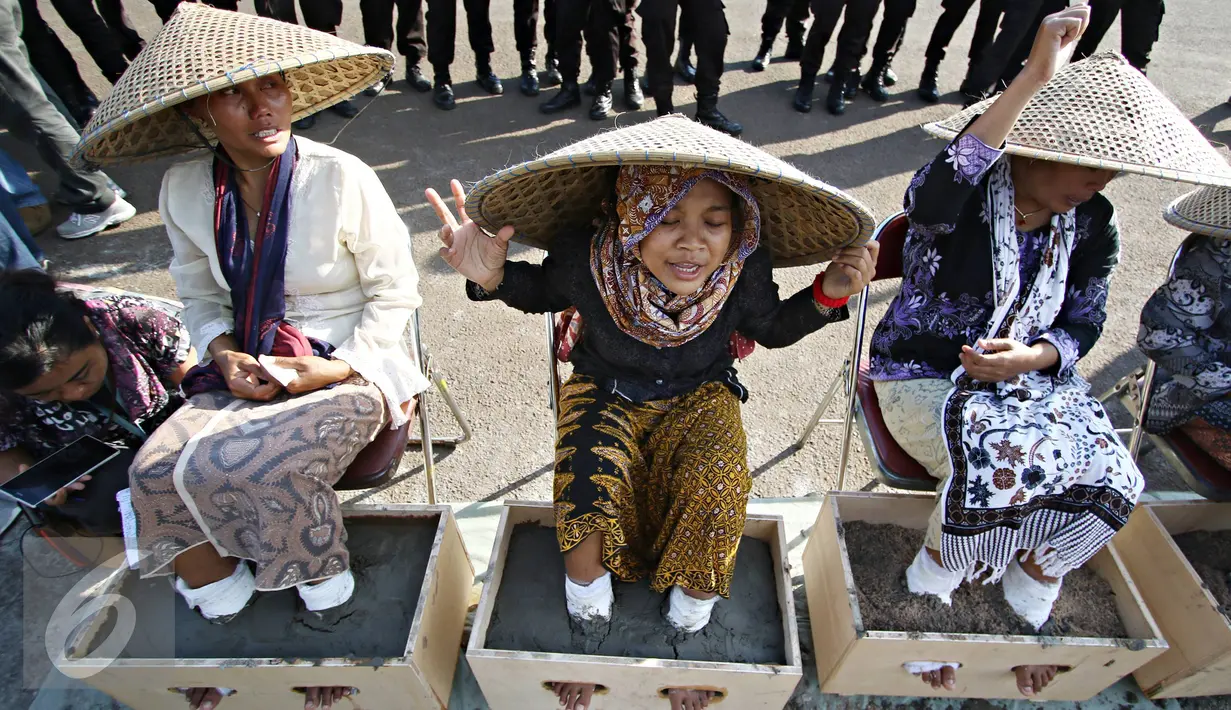Sejumlah perempuan asal Pegunungan Kendeng, Jawa Tengah melakukan aksi semen kaki di depan Istana Negara, Jakarta, Selasa (12/4). Aksi tersebut merupakan bentuk protes atas pembangunan pabrik semen di wilayah mereka. (Liputan6.com/Immanuel Antonius) 