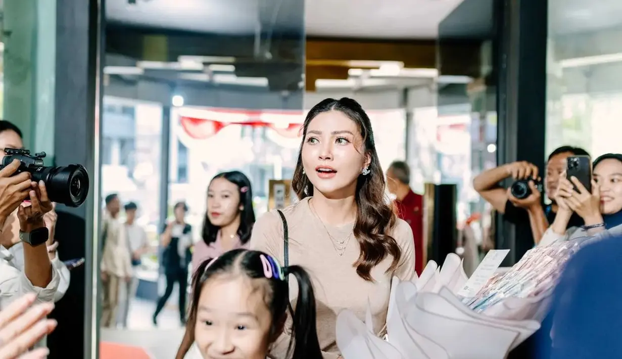 Dengan makeup soft glam bernuansa gold, Sarwendah tata rambut mediumnya dengan sleek half ponytail [@theonsufamily]