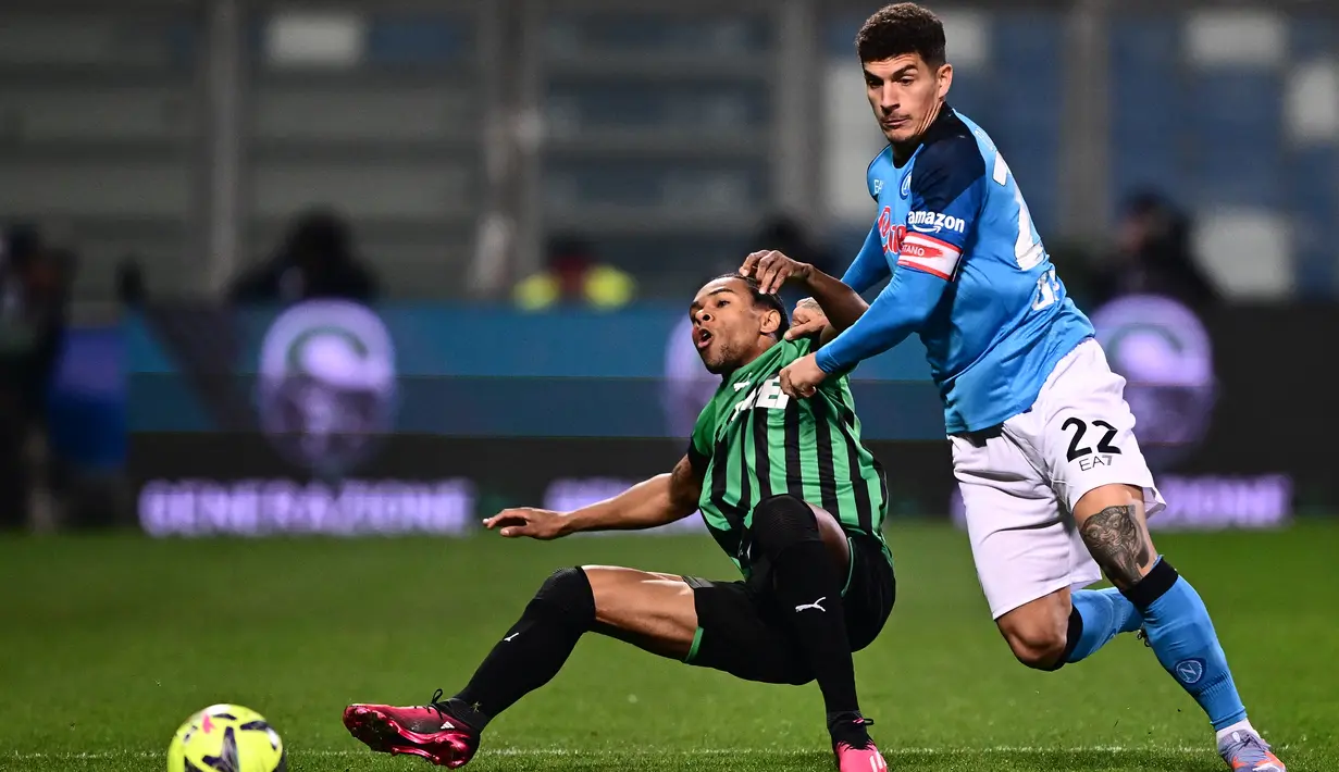 <p>Penyerang Sassuolo, Armand Lauriente (Tengah) dan bek Napoli Italia Giovanni Di Lorenzo mengejar bola selama pertandingan lanjutan Liga Serie A Italia di Stadion Mapei di Reggio Emilia, Italia, Sabtu (17/2/2023). Napoli menang atas Sassuolo dengan skor 2-0. (AFP/Marco Bertorello)</p>