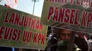Massa membawa poster saat melakukan aksi mendukung Revisi UU KPK di depan Gedung DPR/MPR RI, Jakarta, Rabu (11/9/2019). Mereka menyuarakan pro dan kontra terhadap revisi Undang-Undang Nomor 30 Tahun 2002 tentang Komisi Pemberantasan Tindak Pidana Korupsi. (Liputan6.com/Johan Tallo)