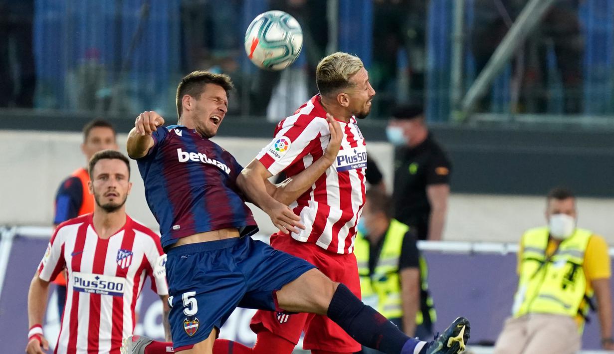 Pemain Atletico Madrid, Hector Herrera, duel udara dengan pemain Levante, Nemanja Radoja, pada laga La Liga di Stadion Camilo Cano, Selasa (23/6/2020). Atletico Madrid menang 1-0 atas Levante. (AFP/Jose Jordan)