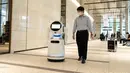 Seorang staf mencoba menggunakan sebuah robot pemandu dalam uji coba yang dilakukan di sebuah bangunan komersial di Tokyo, Jepang (14/9/2020). Acara tersebut, sebagai bagian dari proyek "Tokyo Robot Collection" yang diprakarsai pemerintah kota metropolitan Tokyo. (Xinhua/Pemerintah Kota Metropolitan